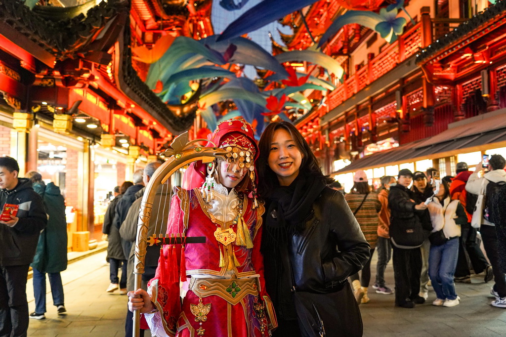 11月30日，來自韓國的游客（右）在上海豫園商城與游戲角色裝扮者合影。新華社發(fā)（謝鑫 攝）