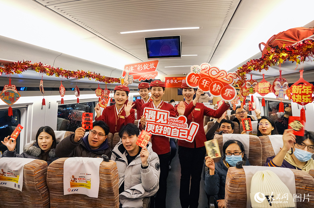 12月30日，乘務(wù)人員與旅客在車廂內(nèi)互動(dòng)合影留念迎接2025的到來。