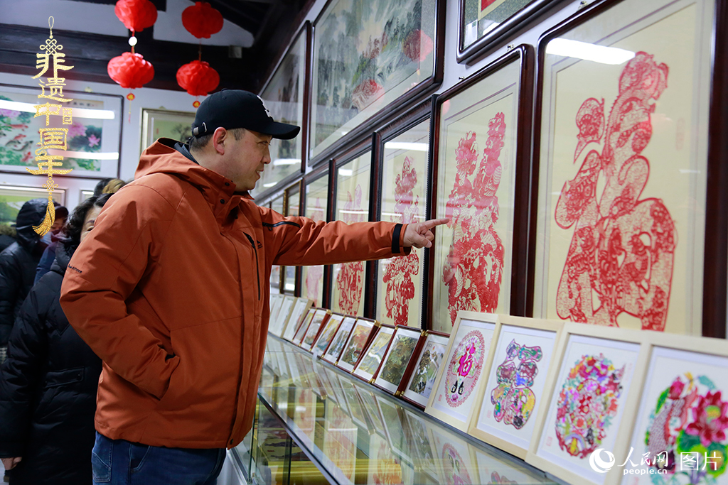2025年1月23日，游客在天津楊柳青古鎮(zhèn)欣賞傳統(tǒng)剪紙作品，感受指尖上的古老藝術(shù)。人民網(wǎng)記者 崔新耀攝