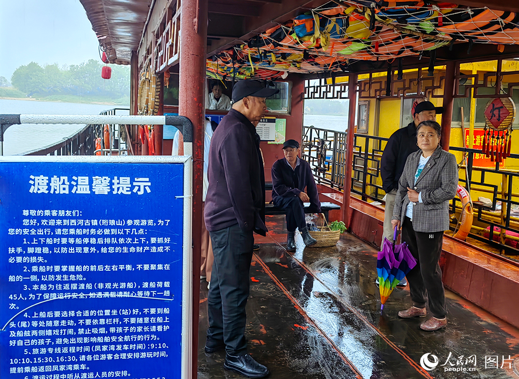西河渡口的渡船上，村民等待渡船開行。