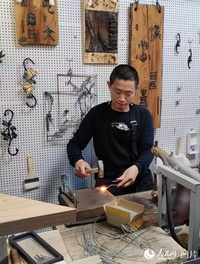 西河古鎮(zhèn)鐵畫工作室內(nèi)，西河鐵畫匠人陶紹軍在制作鐵畫。陶紹軍制作鐵畫已有22年的時(shí)間，從他手中制作出去的成品有很多件，小到梅蘭竹菊四條屏、各種賽事的吉祥物，大到掛滿一面墻的大件。