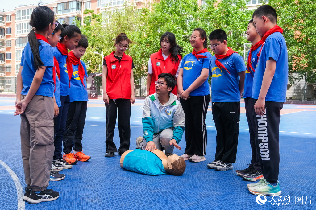 4月23日，學(xué)院學(xué)生代表為小學(xué)生們演示講解應(yīng)急救援常識。