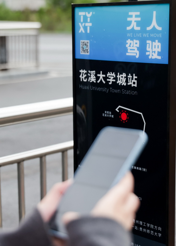 4月24日，在貴陽市花溪大學(xué)城公交車站，前來參與體驗(yàn)活動(dòng)的市民在掃碼試乘無人駕駛公交車。新華社發(fā)（袁福洪攝）