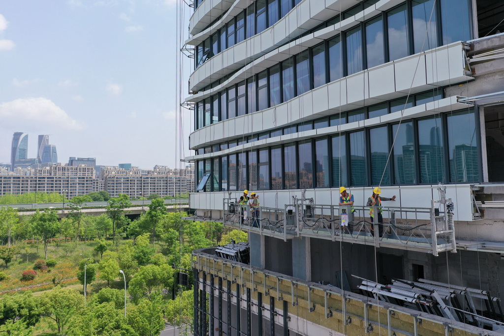 5月1日，中建四局建設(shè)者在浙江大學(xué)醫(yī)學(xué)院附屬婦產(chǎn)科醫(yī)院錢江院區(qū)二期項目現(xiàn)場進行玻璃幕墻安裝作業(yè)（無人機照片）。新華社記者 黃宗治 攝