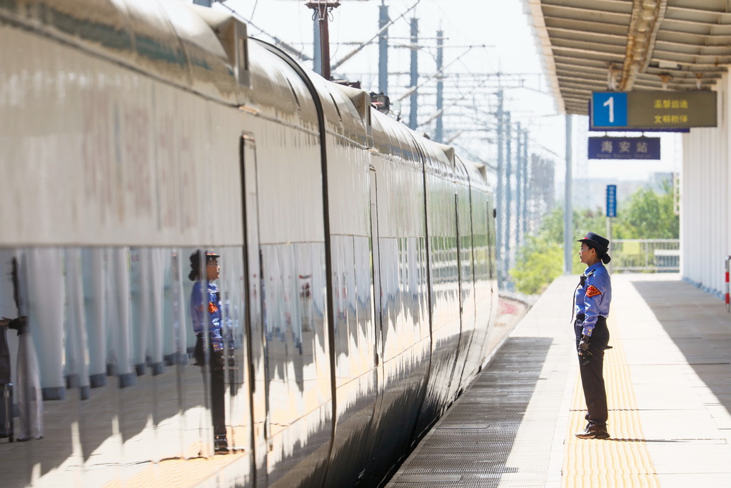 5月1日，在江蘇海安站站臺上，客運(yùn)值班員立崗送車。新華社發(fā)（顧彬斌攝）