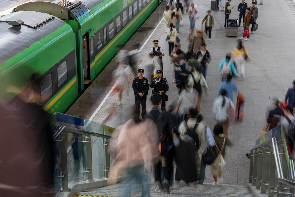5月1日，烏魯木齊鐵路公安處烏魯木齊站派出所民警在站臺(tái)引導(dǎo)旅客安全乘車。新華社發(fā)（葉帥 攝）