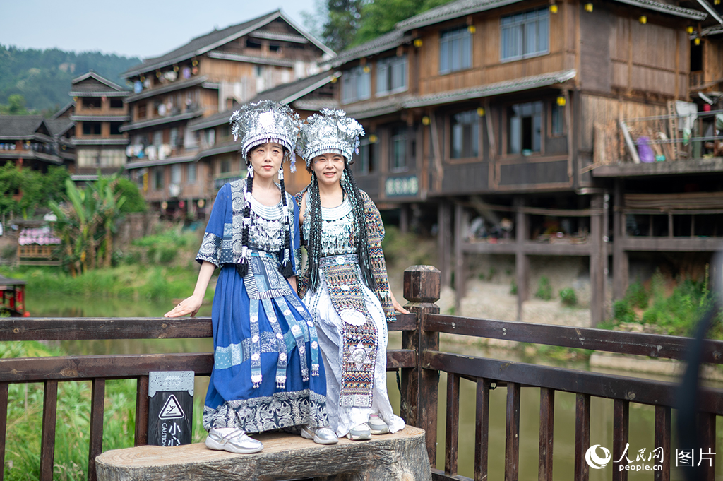 2025年5月3日，在廣西三江侗族自治縣程陽八寨景區(qū)，游客穿上民族服裝合影留念。人民網(wǎng)記者 嚴(yán)立政攝