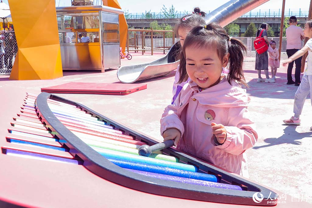 2025年5月3日，山西省太原市晉源區(qū)稻田公園，一位小朋友開心地敲擊兒童鋼管琴。人民網(wǎng)記者 王帆攝
