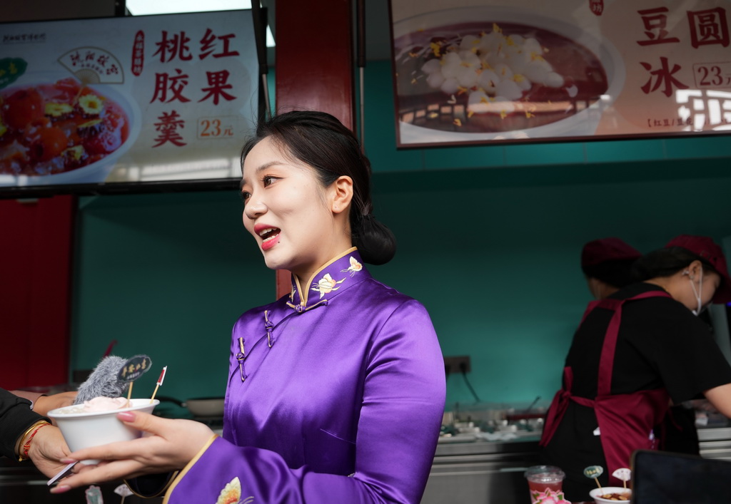 2024年5月10日，沈陽故宮博物院講解員為游客介紹美食文創(chuàng)產(chǎn)品。新華社記者 李鋼 攝
