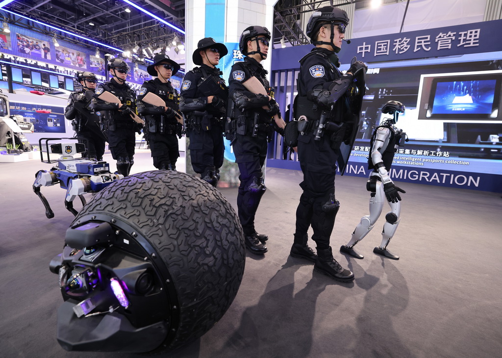 5月14日，在第十二屆中國國際警用裝備博覽會移民管理裝備展區(qū)，民警和球形機器人、警用機器狗和具身人形智能警務(wù)機器人（右一）一起進(jìn)行巡邏演練。新華社記者 殷剛 攝