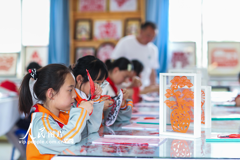 2025年5月17日，在陜西省旬邑縣逸夫小學(xué)，學(xué)生在老師的指導(dǎo)下學(xué)習(xí)剪紙。