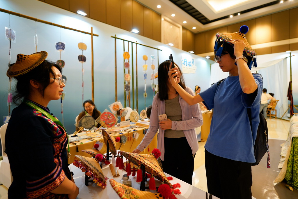 5月28日，在成都國際非遺節(jié)“魅力非遺·國際大展”現(xiàn)場(chǎng)，參觀者體驗(yàn)毛南族花竹帽。