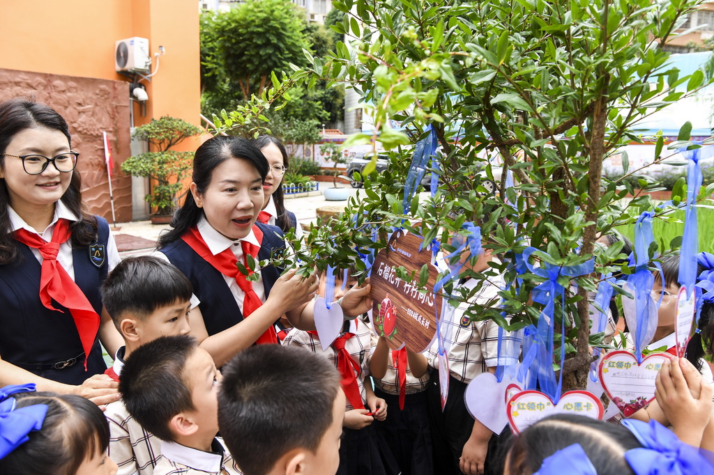5月30日，在廣西南寧市濱湖路小學(xué)教育集團(tuán)濱湖校區(qū)少先隊(duì)員入隊(duì)儀式結(jié)束后，老師與新入隊(duì)的少先隊(duì)員們一起種下象征團(tuán)結(jié)的石榴樹(shù)，并在心愿卡上寫(xiě)下心愿與祝福。