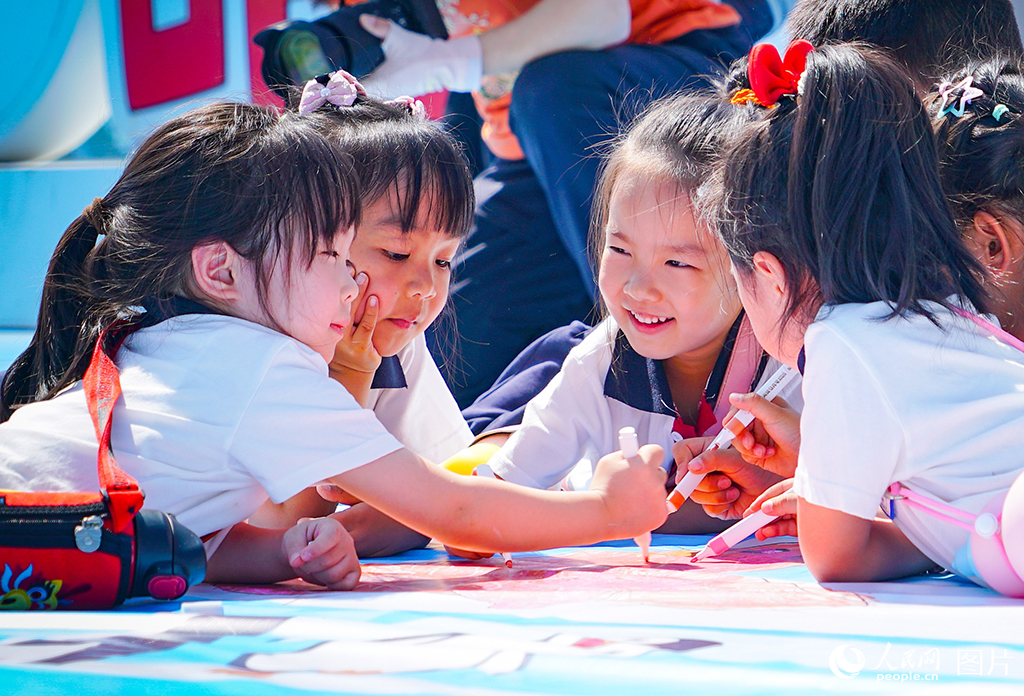 2025年5月27日，在黑龍江省哈爾濱極地公園，百名兒童在巨幅畫布上揮灑童心，用五彩筆觸描繪心目中的美麗世界。人民網(wǎng)記者 蘇靖剛攝
