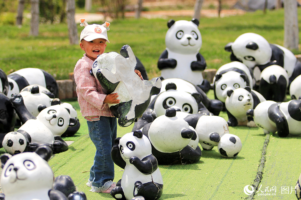 2025年5月29日，甘肅省蘭州野生動物園，萌娃搬運(yùn)胖達(dá)，童趣滿滿。人民網(wǎng)記者 米媛攝