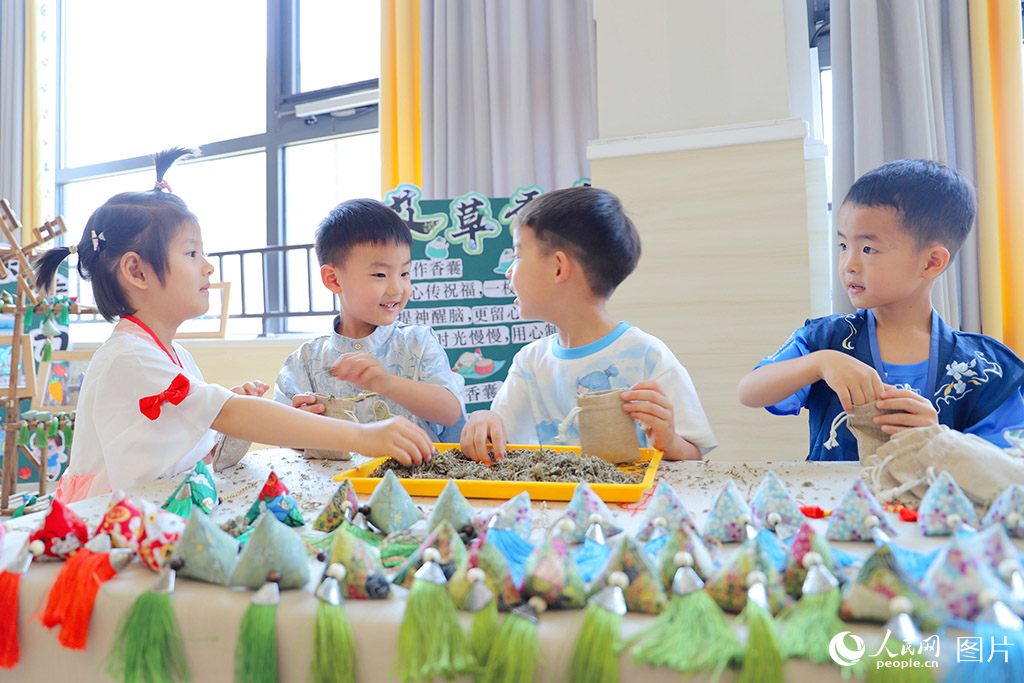 2025年5月30日，山東省濟(jì)南市歷下區(qū)百合幼兒園的孩子們巧手縫制艾草香包，喜迎六一端午雙節(jié)。人民網(wǎng)記者 劉祺攝