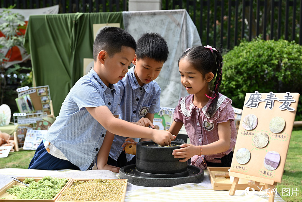 2025年5月30日，在河南省鄭州市二七區(qū)第一幼兒園連云路園區(qū)，小朋友們在體驗(yàn)?zāi)デ帑?，感悟農(nóng)耕文明。人民網(wǎng)記者 王玉興攝