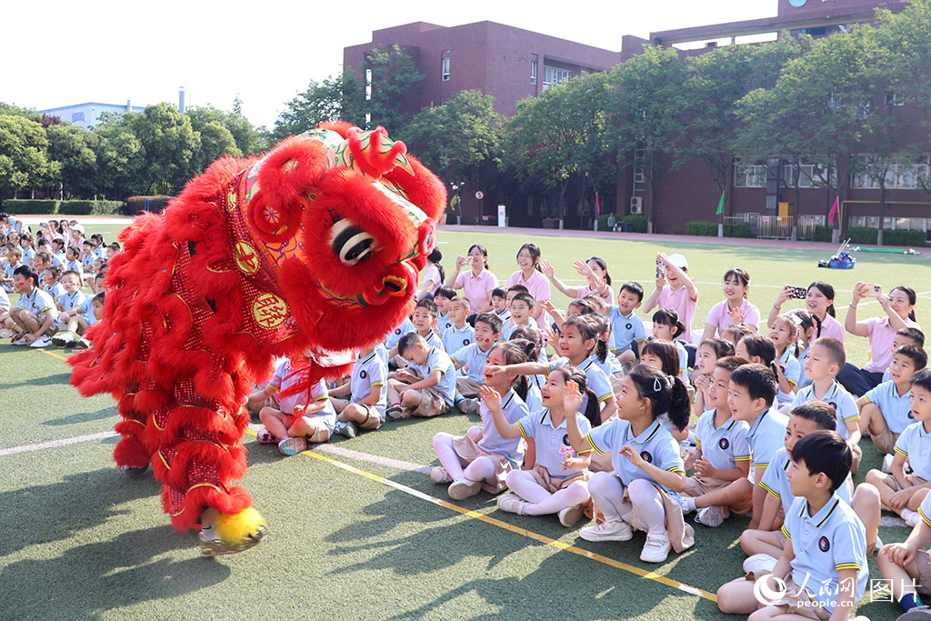 兒童節(jié)前夕，陜西省西安市第五保育院舉辦親子運(yùn)動會，孩子們與舞獅表演互動，現(xiàn)場一片歡聲笑語。人民網(wǎng)記者 白鴿攝