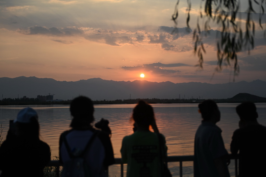 游客在寧夏銀川覽山公園觀賞賀蘭山日落（2024年7月10日攝）。新華社記者 毛竹 攝