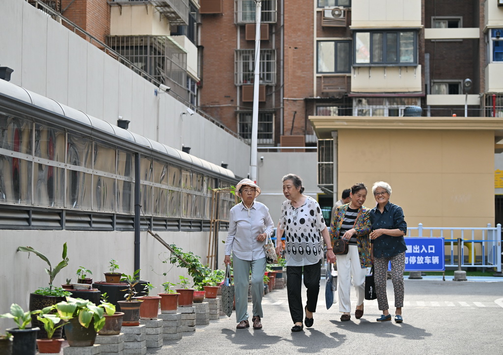 居民在改造翻新后的慶有西里社區(qū)內(nèi)出行（5月29日攝）。