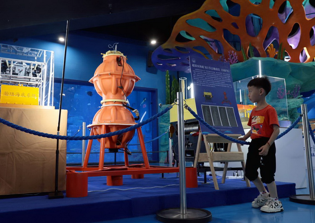 6月7日，一名小朋友在展覽現(xiàn)場了解超深水海底飛行節(jié)點地震儀。